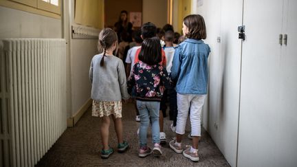 Des élèves rejoignent leur salle de classe, le 2 septembre 2019, à Paris. (MARTIN BUREAU / AFP)