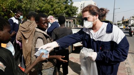 L'association franco-sénégalaise Village Pilote organise des distributions d'eau et de vivres aux enfants de la rue, comme ici à Dakar, le 10 avril 2020. (ZOHRA BENSEMRA / X90036)