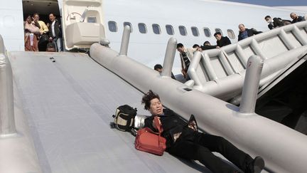 Evacuation de passagers d'un Boeing 747 de Cathay Pacific avant son d&eacute;collage&nbsp;sur l'a&eacute;roport de Shanghai apr&egrave;s que de la fum&eacute;e a &eacute;t&eacute; d&eacute;tect&eacute;e &agrave; l'int&eacute;rieur de l'appareil, le 9 d&eacute;cembre 2011. (AFP)