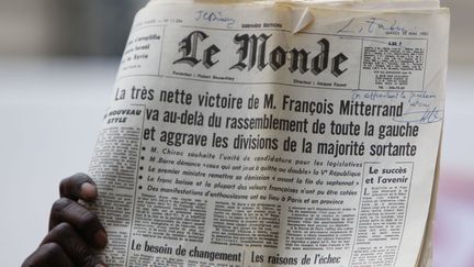 Rue de Solf&eacute;rino &agrave; Paris, un partisan de Fran&ccedil;ois Hollande brandit la une du quotidien "le Monde"&nbsp;annon&ccedil;ant la victoire de Fran&ccedil;ois Mitterrand en 1981. (KENZO TRIBOUILLARD / AFP)