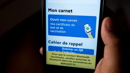 Une personne montre son certificat de vaccination sur l'application TousAntiCovid, le 12 juin 2021. (FREDERIC SCHEIBER / HANS LUCAS / AFP)