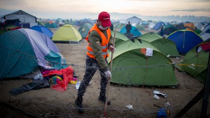 "Il y a vraiment une grande solidarité de la part des populations locales. On a recruté beaucoup de grecs ces dernières semaines", reconnaît la chargée de mission de MSF. A l'image de ce bénévole qui nettoie le camp, le 6 mars 2016. (KAY NIETFELD / DPA)