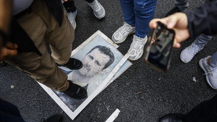 Un portrait de Bachar al-Assad, président syrien déchu, piétiné par la foule, le 8 décembre 2024, devant l'ambassade syrienne à Istanbul (Turquie). (KEMAL ASLAN / AFP)