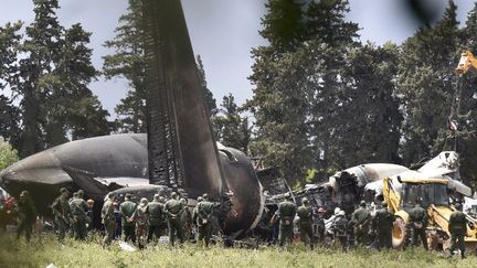 Des sauveteurs autour des débris de l'Iliouchine de l'armée algérienne qui s'est écrasé près de la base de Boufarik d'où il venait de décoller, le 11 avril 2018, faisant 257 morts. (RYAD KRAMDI/AFP)