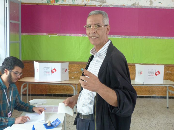 Dans un bureau de vote à&nbsp;Etta(hamen (banlieue de Tunis), lors du 2n tour de la présidentielle le 13 octobre 2019, un électeur montre le bout de son doigt couvert d'encre : la preuve qu'il a accompli son devoir électoral. (AFP - Laurent Ribadeau Dumas)