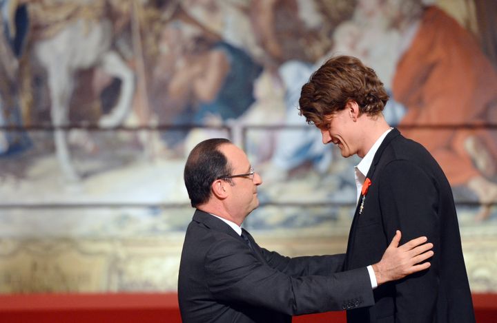 Le nageur Yannick Agnel se penche pour parler au président&nbsp;François Hollande à Paris, le 1er mars 2013. (AFP)