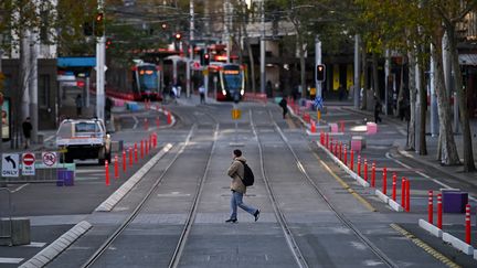 Un homme traverse la rue George à Sydney (Australie), le 26 juin 2021. (STEVEN SAPHORE / ANADOLU AGENCY / AFP)