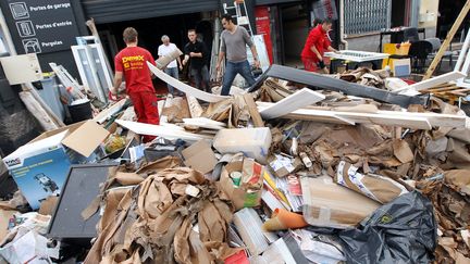 Des ouvriers nettoient une zone industrielle touch&eacute;e par les inondations, &agrave; Fr&eacute;jus (Var), le 8 novembre 2011. (VALERY HACHE / AFP)