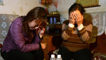 La m&egrave;re et la grand-m&egrave;re d'une des fillettes empoisonn&eacute;es par la responsable d'un jardin d'enfants, le 2 mai 2013 &agrave; Pingshan (province du Hebei), en Chine. (STR / AFP)