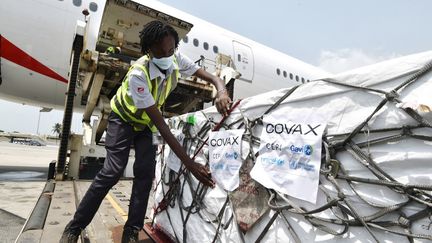 Des caisses de vaccins AstraZeneca contre le Covid-19 sont déchargées d'un avion sur le tarmac de l'aéroport&nbsp;Felix Houphouet Boigny, à Abidjan, en Côte d'Ivoire, le 26 février 2021. (SIA KAMBOU / AFP)