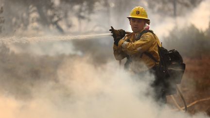 Un pompier de Californie éteint un point chaud à proximité de Jerseydale, en Californie, le 24 juillet 2022, alors que le feu fait rage près du parc national Yosemite. (JUSTIN SULLIVAN / GETTY IMAGES NORTH AMERICA)