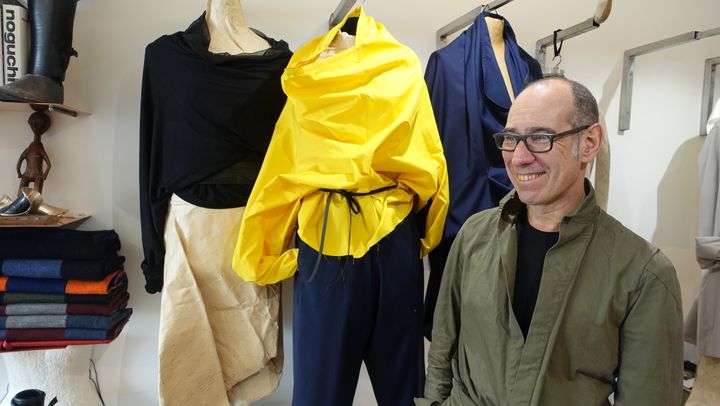 Gustavo Lins dans son atelier-galerie parisien, devant sa pièce préférée, une blouse en popeline jaune, avril 2018 
 (Corinne Jeammet)