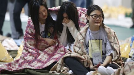 Des rescap&eacute;es du naufrage du ferry Sewol pleurent apr&egrave;s avoir &eacute;t&eacute; recueillies dans un gymnase &agrave; Jindo (Cor&eacute;e du Sud), le 16 avril 2014. (KIM HONG-JI / REUTERS)