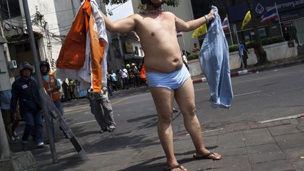 Un manifestant anti-gouvernement enl&egrave;ve ses v&ecirc;tements et nargue les policiers &agrave; Bangkok (Tha&iuml;lande), le 18 f&eacute;vrier 2014. (KC ORTIZ / AFP)