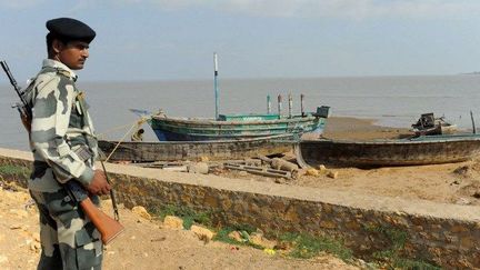 Un soldat indien monte la garde devant des bateaux confisqués à des pêcheurs pakistanais. (AFP/Sam Panthaky)