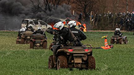 Un gendarme mobile anti-émeutes, circulant en quad, tire avec un LBD sur les manifestants lors de la manifestation contre les "méga-bassines" à Sainte-Soline (Deux-Sèvres), le 25 mars 2023. (THIBAUD MORITZ / AFP)