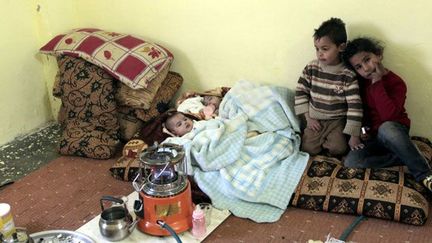 Le 20 février 2012, des enfants sont rassemblés dans une salle chauffée d’un camp partiellement mis en place dans la ville d’al-Mafraq, près de la frontière nord de la Jordanie. 

Ce sont près de 80 000 syriens qui ont trouvé refuge en Jordanie. ( AFP PHOTO / KHALIL MAZRAAWI)