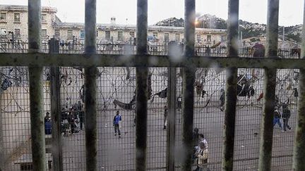 &nbsp; (Les détenus profitent de la promenade pour récupérer des colis lancés dans la cour © Maxppp)