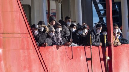 Des migrants arrivent à bord d'un bâteau de l'ONG Sea-Eye dans le port de Pozzallo, en Sicile (Italie), le 24 décembre 2021. (GIOVANNI ISOLINO / AFP)