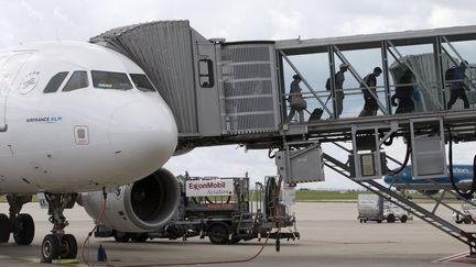 Des passagers sortent d'un avion de l'aéroport de Roissy. Image d'illustration. (KENZO TRIBOUILLARD / AFP)