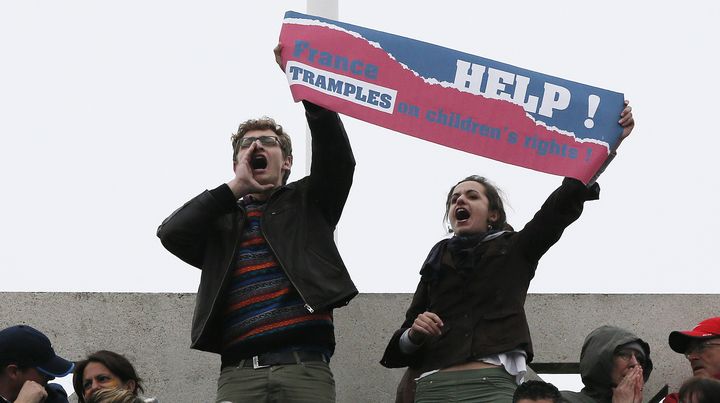 Deux militants anti-mariage pour tous brandissent une banderole sur le court Philippe-Chatrier lors de la finale de Roland-Garros, le 9 juin 2013. (PATRICK KOVARIK / AFP)