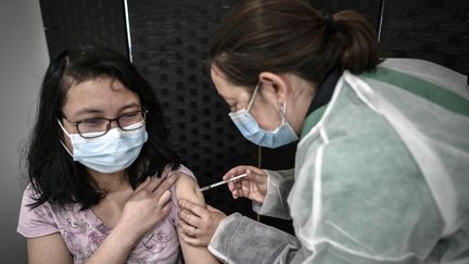 Une femme reçoit une dose du vaccin Pfizer-BioNTech contre le Covid-19 à Versailles (Yvelines) le 29 mai 2021. (STEPHANE DE SAKUTIN / AFP)