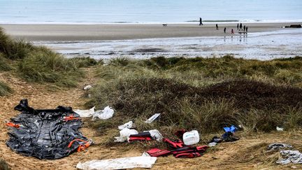 Un bateau pneumatique, des gilets de sauvetage retrouvés échoués sur une dune de sable de la plage de Wimereux, dans le nord de la France après le naufrage de 27 migrants dans la Manche, le 24 novembre 2021. (FRANCOIS LO PRESTI / AFP)