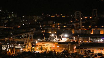 Les décombres du pont Morandi à Gênes (Italie) éclairés pour permettre la poursuite des recherches la nuit, le 15 août 2018. (PIERO CRUCIATTI / AFP)