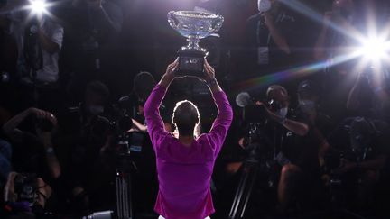 Rafael Nadal soulève son 21e trophée en Grand Chelem, à Melbourne (Australie), le 31 janvier 2022. (BRANDON MALONE / AFP)