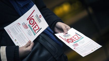 Un militant PS distribue des tracts, le 18 décembre 2016 à Paris, pour inciter les électeurs à aller voter à la primaire de la gauche. (ETIENNE LAURENT / EPA)