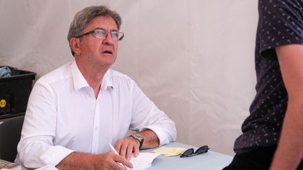 Le leader de la France insoumise Jean Luc Mélenchon, en pleine séance de dédicace lors de la première journée des AMFIS, les universités d'été du parti de gauche La France Insoumise, à Châteauneuf-sur-Isère, dans la Drôme.&nbsp; (NICOLAS GUYONNET / HANS LUCAS)