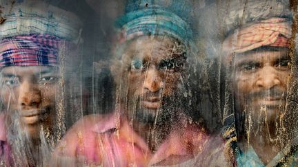 Second prix. Cette fabrique de gravier reste pleine de poussi&egrave;re et de sable. Ces trois ouvriers regardent &agrave; travers la vitre, de leur place de travail.&nbsp;National Geographic Contest (FAISAL AZIM)