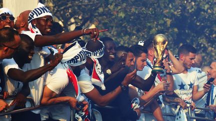 Les joueurs de l'équipe de France défilent sur les Champs-Elysées, lundi 16 juillet, et présentent le le trophée aux supporters. (ZAKARIA ABDELKAFI / AFP)