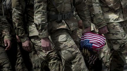 Des soldats américains arrivent pour placer des drapeaux devant des tombes au cimetière national d'Arlington pour le Memorial Day, le 25 mai 2017 à Arlington, en Virginie. (BRENDAN SMIALOWSKI / AFP)