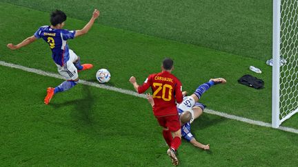 Le Japonais Kaoru Mitoma tacle un ballon sur la ligne, quelques instants avant un but décisif contre l'Espagne, le 1er décembre 2022 à Doha (Qatar). (GIUSEPPE CACACE / AFP)