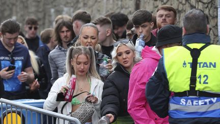 Des participants patientent à l'entrée du Circus, une boîte de nuit de Liverpool (Royaume-Uni), où est organisée une soirée-test pour évaluer le risque de contaminations, le 30 avril 2021. (PETER BYRNE / PA / AP)