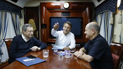 Emmanuel Macron entouré du chancelier allemand Olaf Scholz (D) et du Premier ministre italien Mario Draghi (G) dans un train qui les mène vers Kiev en Ukraine, le 16 juin 2022. (LUDOVIC MARIN / POOL / VIA AFP)