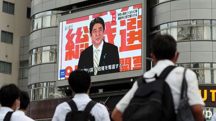 Un écran affiche le visage de l'ancien Premier ministre Shinzo Abe dans la ville de Nagoya (Japon), le 8 juillet 2022. (MASANORI INAGAKI / YOMIURI / AFP)