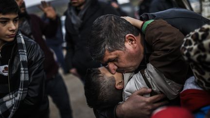 Un père et son fils arrivés d'Iblid en Syrie, à la frontière turque dans la province de&nbsp;Reyhanli (BULENT KILIC / AFP)
