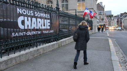 A Saint-Quentin (Aisne), une femme passe devant une banderole d&eacute;ploy&eacute;e en hommage aux victimes de l'attentat contre "Charlie Hebdo", le 12 janvier 2015. (BASTIEN HUGUES / FRANCETV INFO)