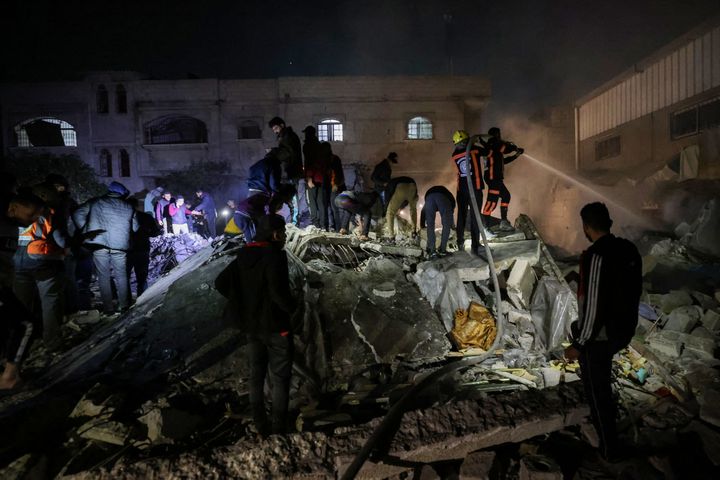 Firefighters and civilians try to find survivors in the rubble of a building, in Rafah, in the Gaza Strip, December 18, 2023. (MOHAMMED ABED / AFP)