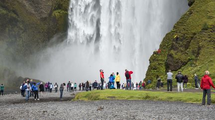 Des touristes près d'une cascade, au sud de l'Islande, le 9 août 2015. (photo d'illustration) (HALLDOR KOLBEINS / AFP)