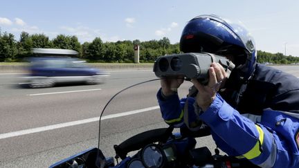 Un gendarme contrôle la vitesse des automobilistes sur l'autoroute A6/A31, à hauteur de Beaune (Côte-d'Or), en juillet 2013 (photo d'illustration) (KENZO TRIBOUILLARD / AFP)