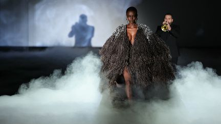 Un mannequin et le musicien Ibrahim Maalouf au défilé haute couture printemps-été 2024 de Stéphane Rolland, salle Pleyel à Paris, le 23 janvier 2024. (THOMAS SAMSON / AFP)