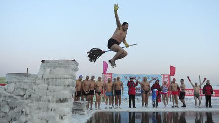 Un nageur s'appr&ecirc;te &agrave; plonger avec une serpilli&egrave;re dans l'eau gel&eacute;e de la rivi&egrave;re Songhua &agrave; Harbin, dans la province de Heilongjiang (Chine), le 26 d&eacute;cembre 2011. (SHENG LI /&nbsp;REUTERS)