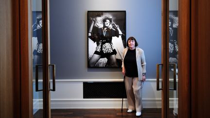 La photographe June Newton ou Alice Springs pose à côté d'un de ses clichés représentant son mari Helmut Newton à l'exposition "Alice Springs" en juin 2010 à Berlin.&nbsp; (JOHANNES EISELE / AFP)