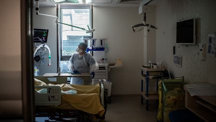 Un médecin discute avec un patient malade du Covid-19 dans un service de réanimation, à l'hôpital Saint-Louis, à Paris, le 28 mai 2020. (MARTIN BUREAU / AFP)