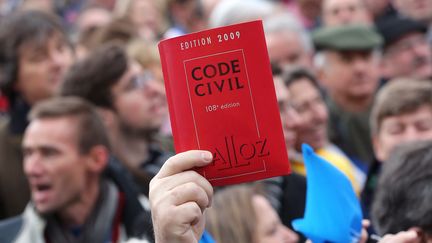 Un manifestant contre le projet de loi sur le mariage pour tous brandit un code civil, le 13 janvier 2013 &agrave; Paris. (THOMAS SAMSON / AFP)