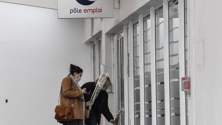 Deux femmes apportent des fleurs devant une antenne de Pole Emploi à Valence, le 29 janvier 2021, au lendemain de la mort de Patricia Pasquion. (PHILIPPE DESMAZES / AFP)