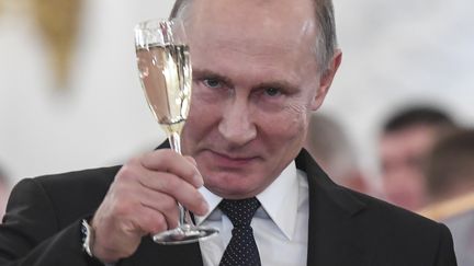 Vladimir Poutine lève son verre après un discours devant des militaires russes de retour de Syrie, le 28 décembre 2017, à Moscou (Russie). (REUTERS)